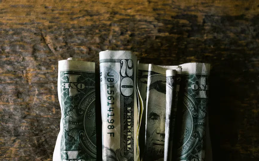 1767800420617_folded bills on wood_inf31363