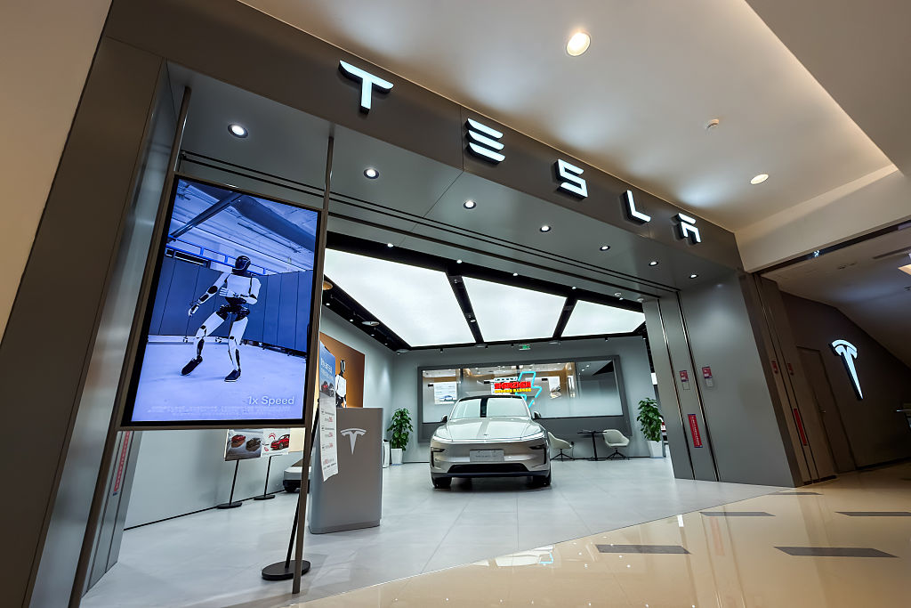 1776954394721_2271281306_shenzhen china a tesla showroom displays a model y vehicle alongside a screen showing the